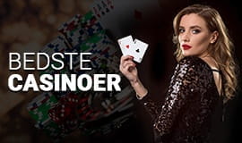 En live casino dealer der holder to spillekort i den ene hånd.