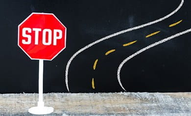 A stop sign next to a winding road