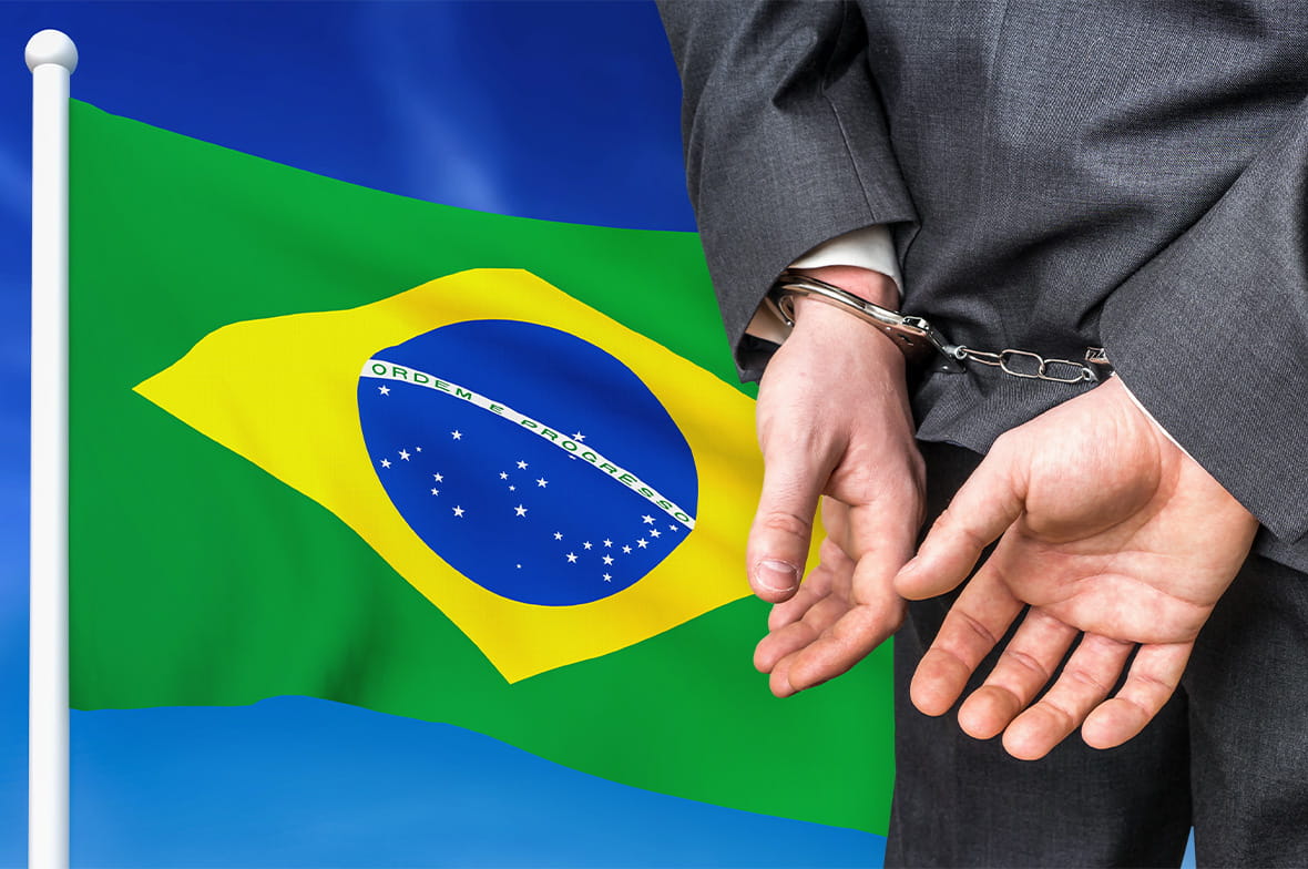 A Man in Handcuffs Next to the Brazilian Flag 