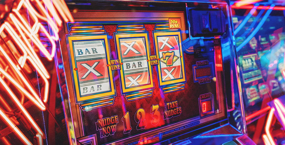 Mesin Slot dengan Lampu Neon Di Sekitarnya 