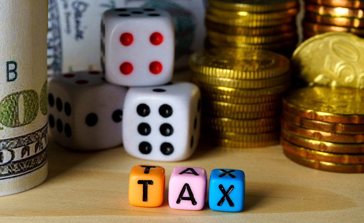 Dice and Hundred-Dollar Bills Symbolise the Impact of Gambling Tax on Winnings. 