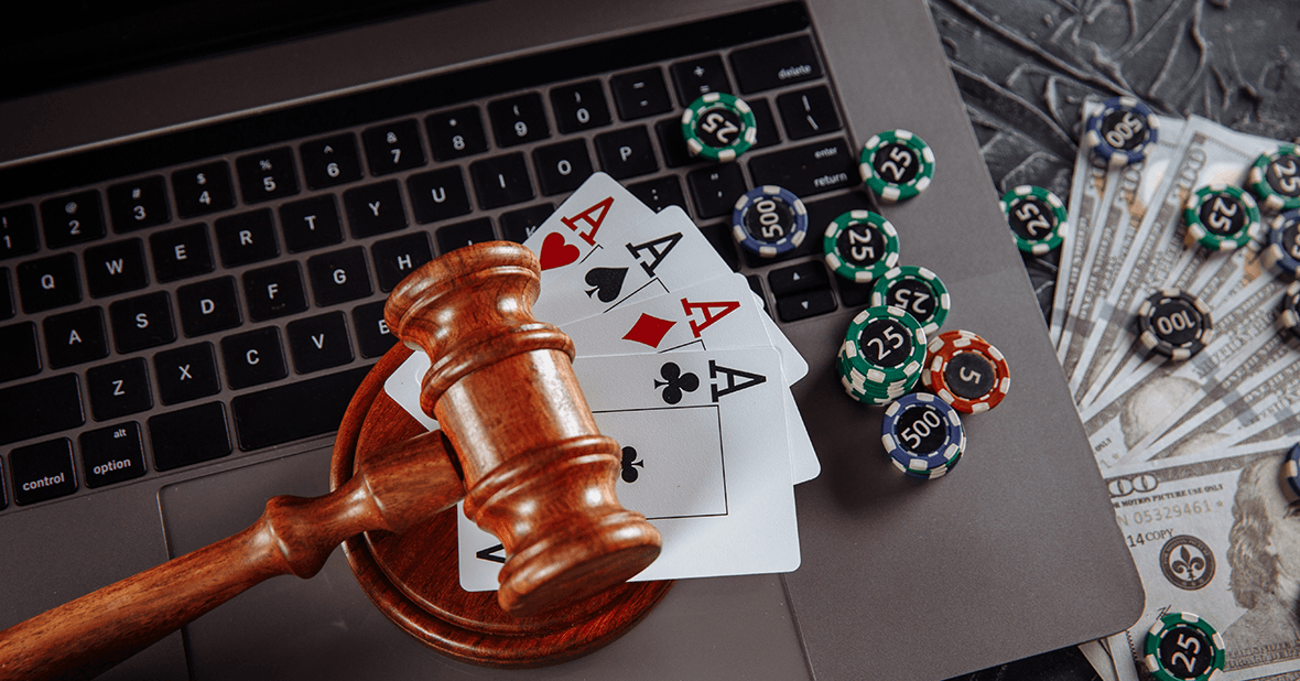 A Gavel with Playing Cards and Money on a Laptop Computer 