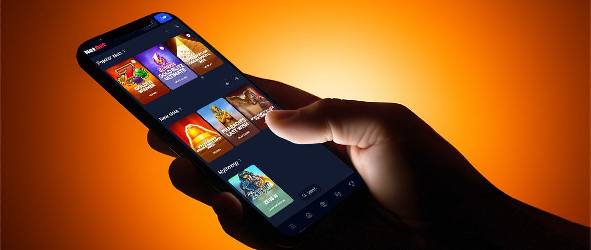 The NetBet Casino lobby on iPhone 15 — Note the provider filter and category navigation tabs.