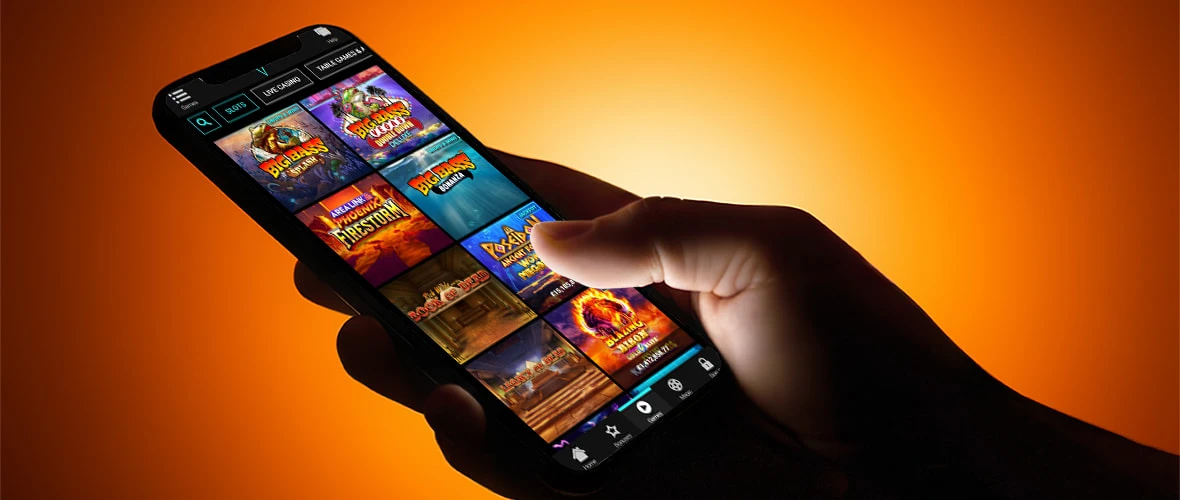The VooDooDreams casino lobby viewed on iPhone 15 — voodoo themed UI with the live-casino tab prominent in the navigation.