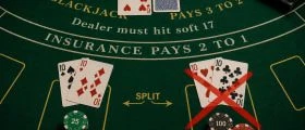 Blackjack table showing a pair of 10s split into two hands, with the split option crossed out in red — illustrating why splitting 10s is a poor move